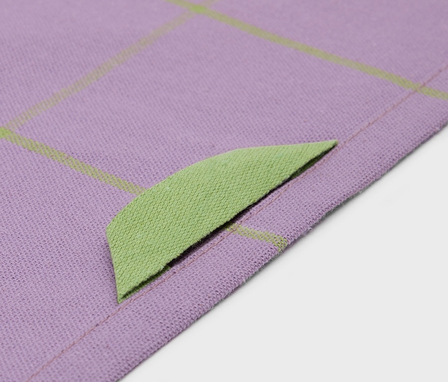 Gros plan d'un tissu violet avec une bordure vert citron et un motif quadrillé.