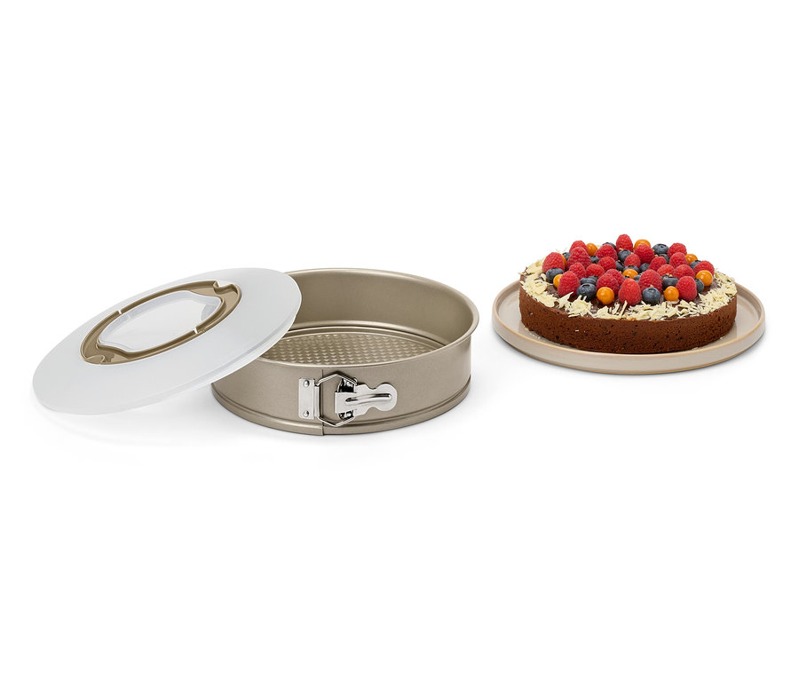 Moule à pâtisserie ouvert à côté d'un gâteau aux fruits.