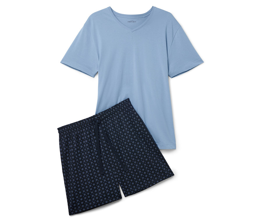 Un t-shirt bleu clair et un short à motifs floraux sont posés sur un fond blanc.