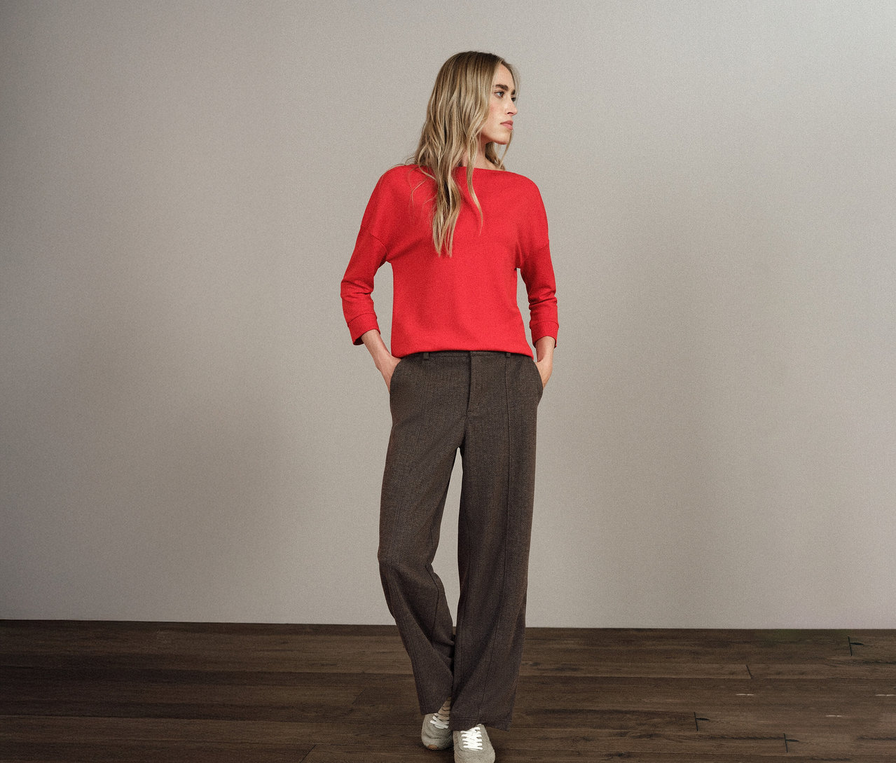 Une femme blonde se tient debout, les mains dans les poches de son pantalon Straight Leg Street One.