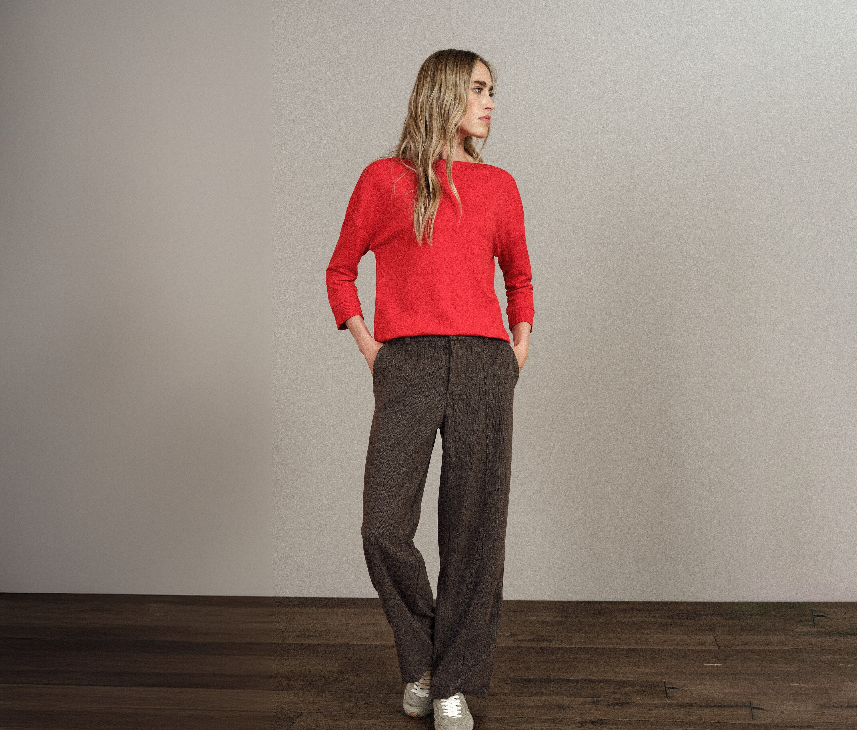 Une femme blonde se tient debout, les mains dans les poches de son pantalon Straight Leg Street One.