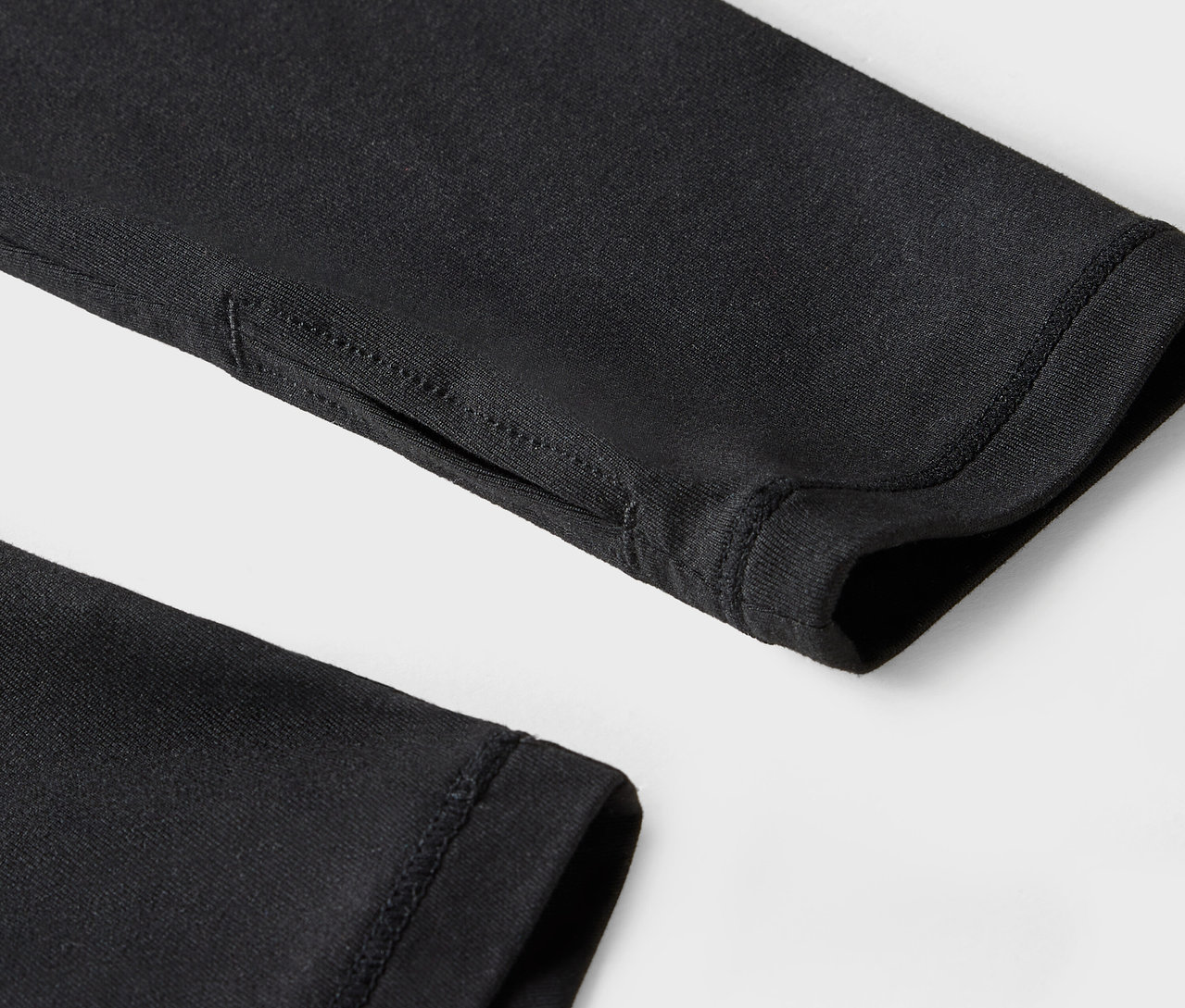 Gros plan sur la manche noire avec un trou pour le pouce.