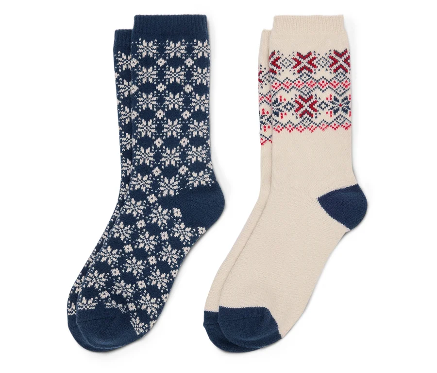 Deux chaussettes : une bleu marine avec des flocons de neige blancs et une beige avec des motifs rouges et bleus.