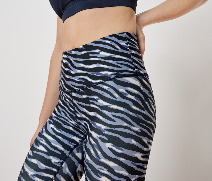 Femme posant en legging à motif animalier et soutien-gorge de sport.