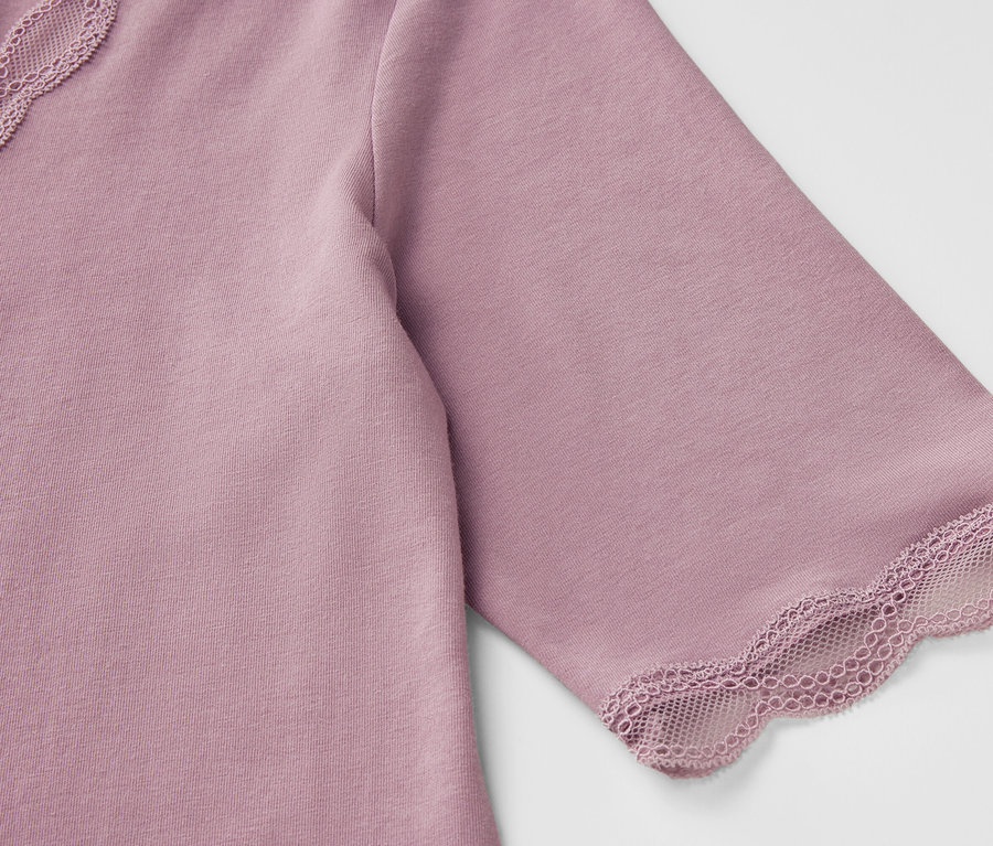 Gros plan sur un t-shirt violet à manches courtes avec des détails en dentelle.