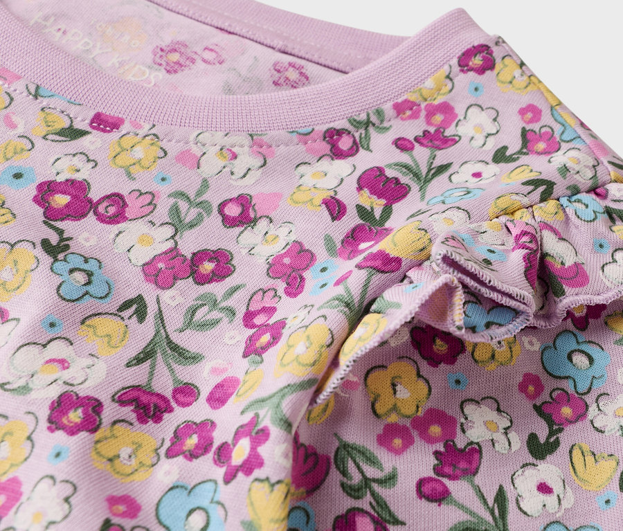 Gros plan sur un t-shirt lilas pour enfant avec un motif floral et une manche à volants.