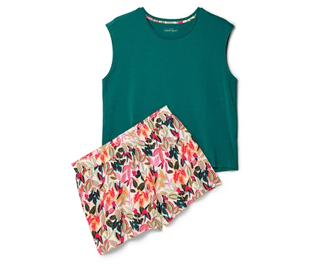 Un débardeur vert et un short à motifs de feuilles sont posés sur un fond blanc.