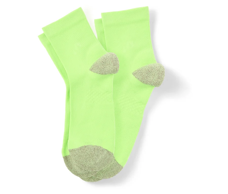 Vue de dessus d'une paire de chaussettes vert clair avec des pointes et des talons gris sur fond blanc.