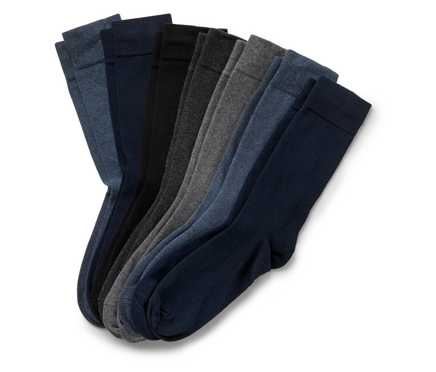 Plusieurs paires de chaussettes unies dans différentes nuances de gris et de bleu sont placées côte à côte.