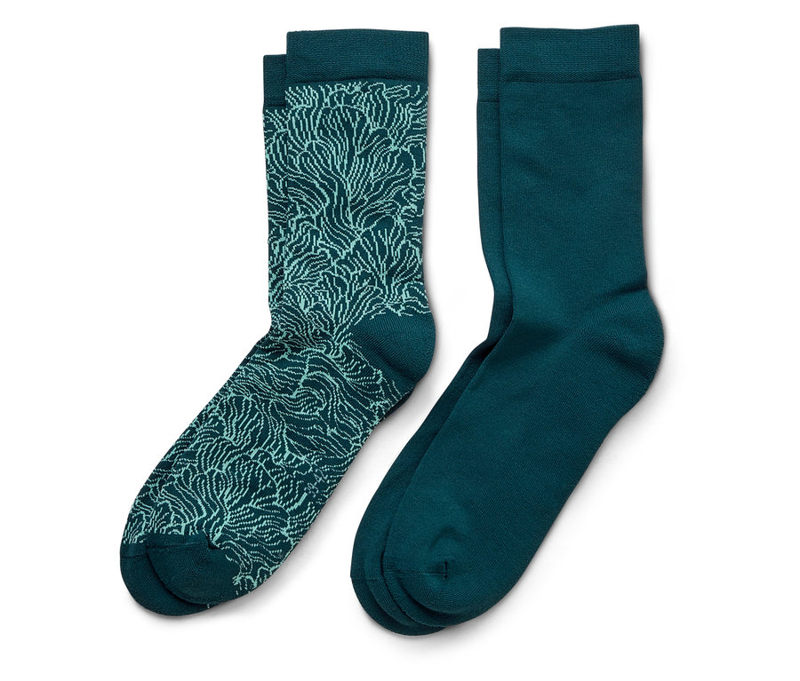 Une paire de chaussettes bleu marine, une avec un motif bleu clair et l'autre unie.