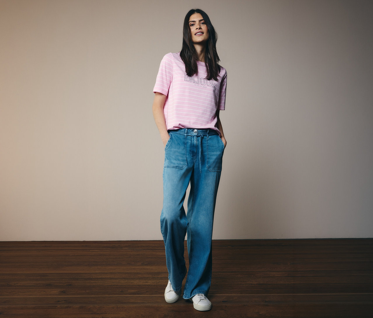 Femme portant un t-shirt rayé et un jean CECIL « Neele » avec les mains dans les poches.