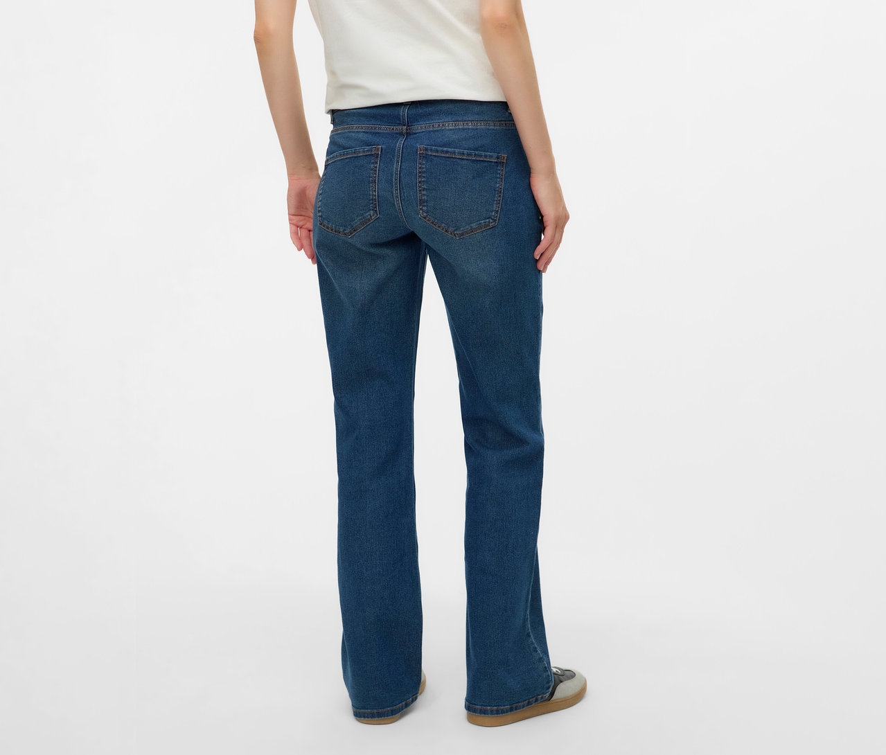 Vue arrière d'une femme portant un t-shirt blanc et un jean évasé MAMALICIOUS « MLEDINA » sur fond blanc.