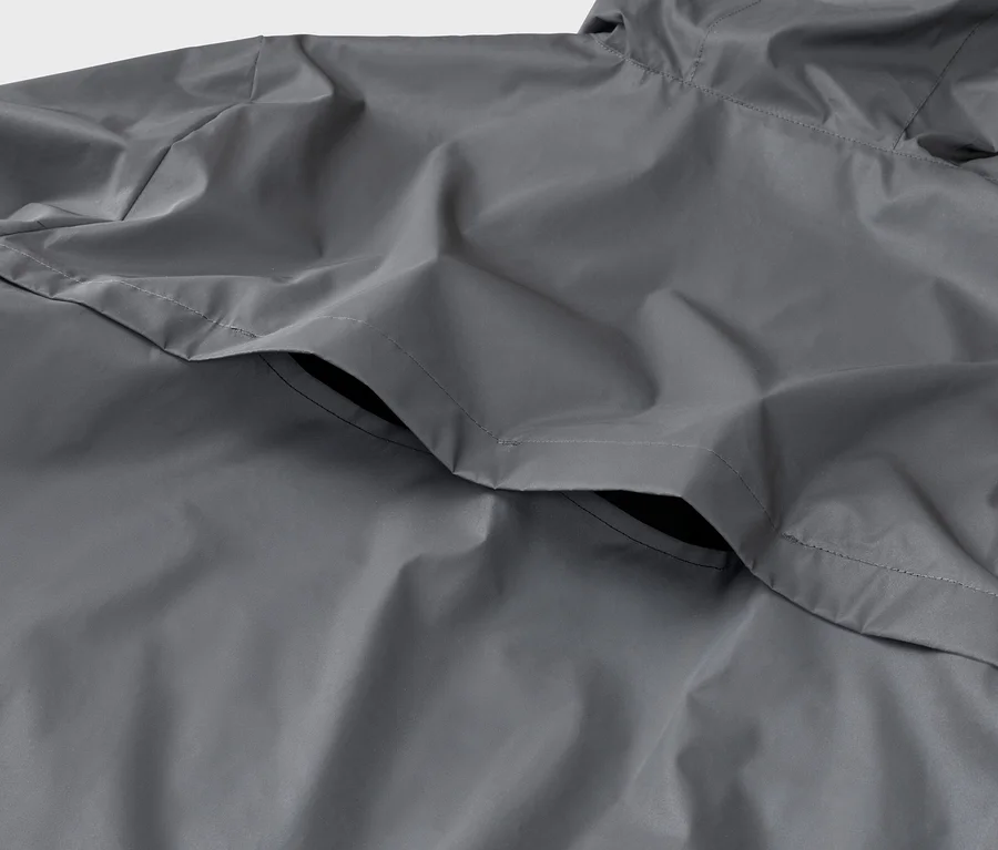Gros plan d'un imperméable gris avec capuche et poche.