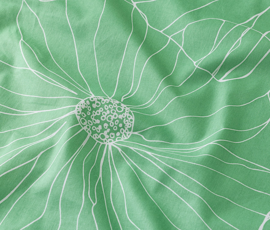 Gros plan d'un tissu vert menthe avec un motif floral blanc.