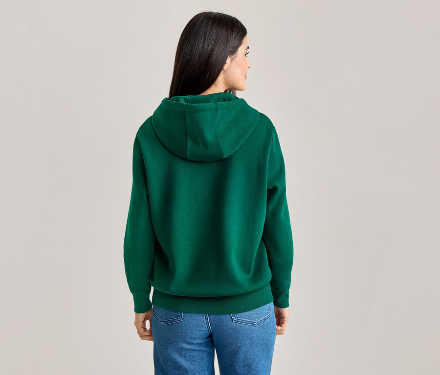 Vue arrière d'une femme aux longs cheveux foncés portant un sweat à capuche vert et un jean bleu.