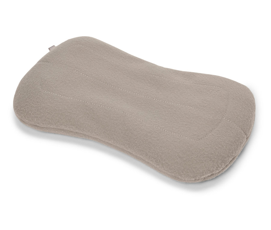 Un coussin beige repose sur un fond blanc.