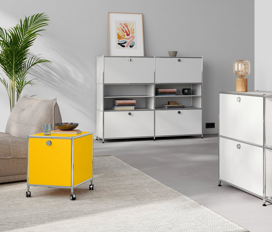 Salon avec lampe de table en bois sur commode en métal «
CN3
» à 4 abattants, blanc. Table d’appoint en métal «
CN3
» jaune avec abattant.