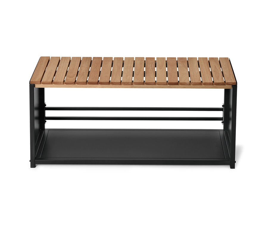 Un banc avec une assise en bois clair et un cadre en métal noir avec une étagère.