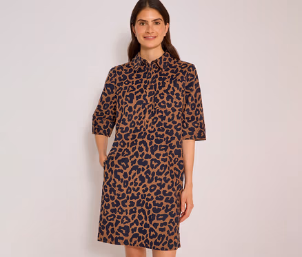Femme souriante portant une robe chemise CECIL à imprimé léopard marron et bleu foncé, manches 3/4, mains dans les poches.