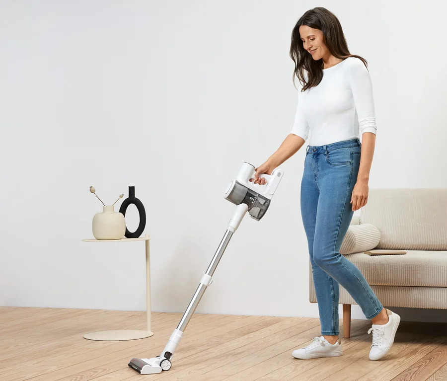 Femme utilisant un aspirateur sur batterie professionnel.
