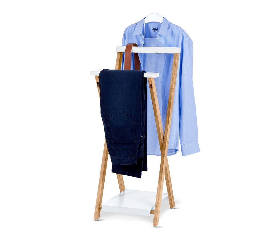 Un portant présente une chemise bleue sur un cintre et un pantalon bleu foncé.