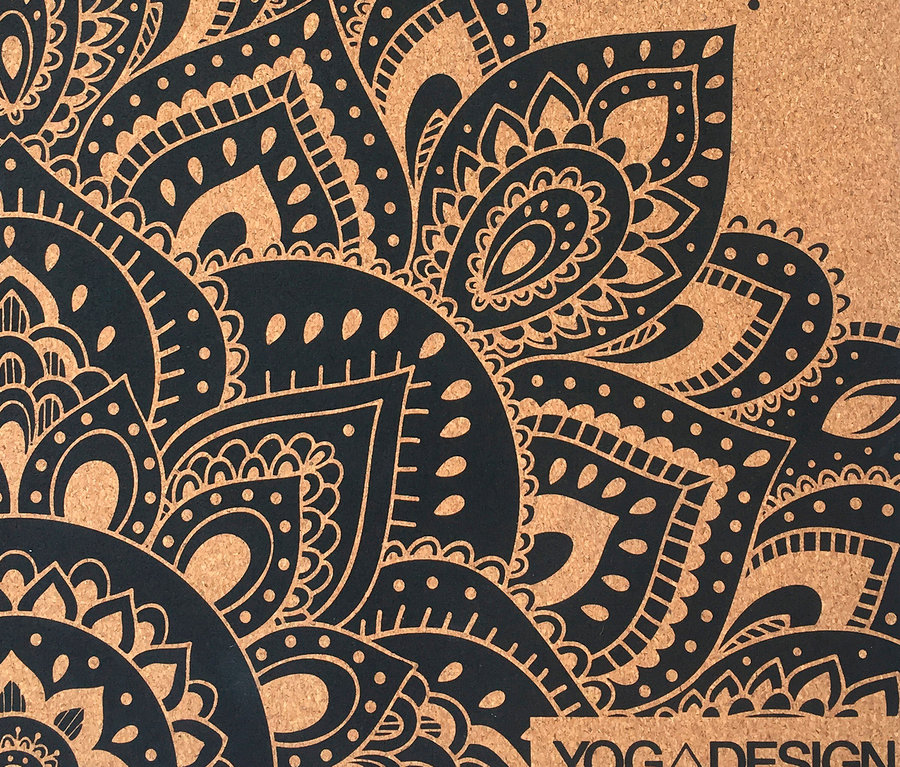 Gros plan sur un tapis de yoga en liège marron avec un motif de mandala noir.