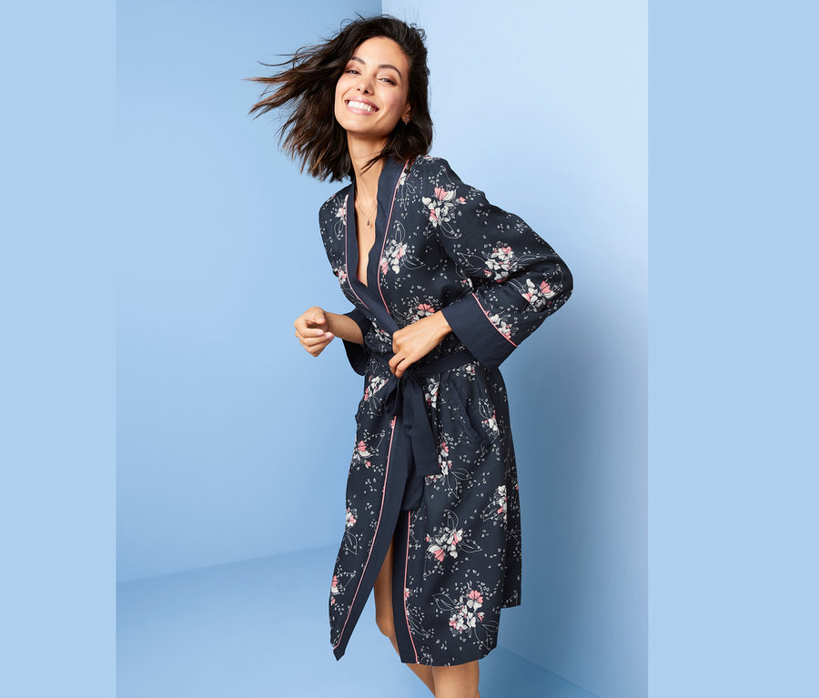 Femme souriante nouant sa robe de chambre à fleurs