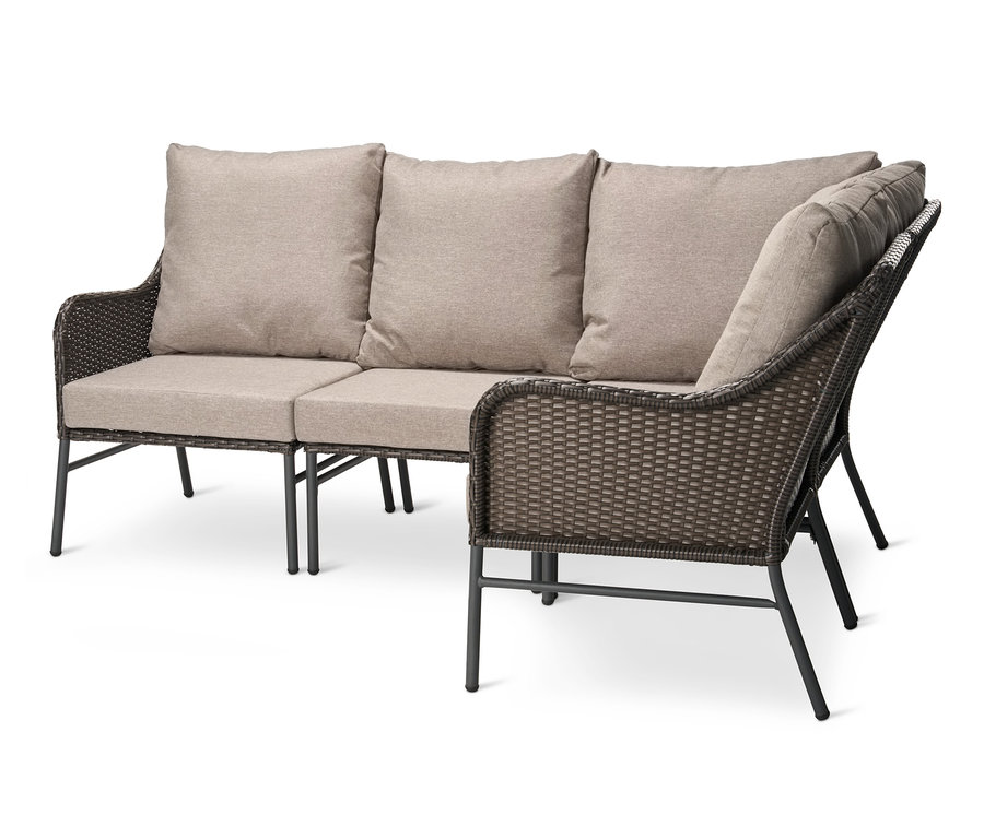 Un canapé d'angle avec tressage en polyrotin et coussins beige.