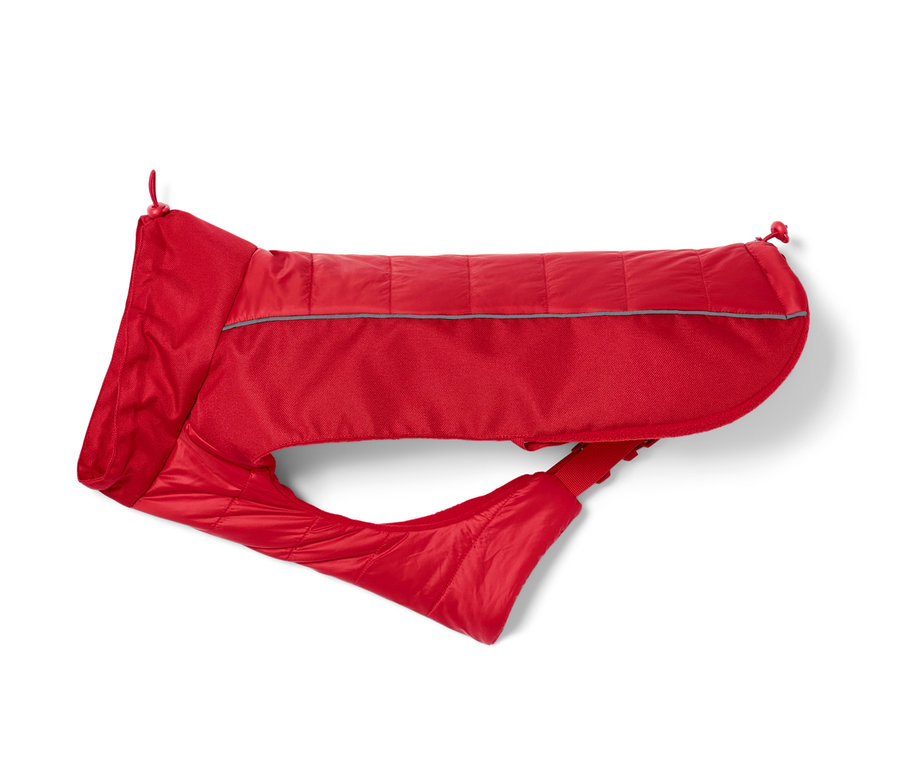 Une veste rouge pour chien repose sur un fond blanc.