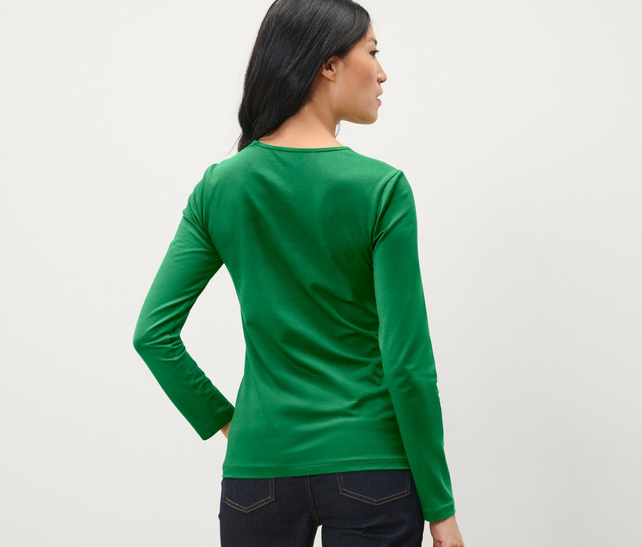 Une femme vue de dos porte un haut manches longues vert.