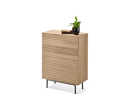 Une commode »Finnsbo« à l'aspect lamellé avec trois tiroirs repose sur des pieds noirs. Un livre et une fleur dans un pot noir sont posés sur la commode.