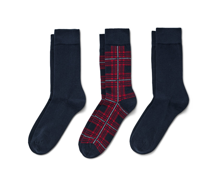 Trois paires de chaussettes : deux bleu marine et une à carreaux.