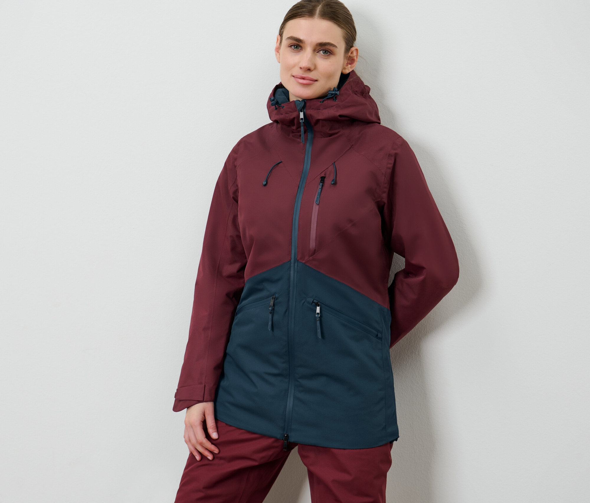 Femme posant en veste de ski et de snowboard.