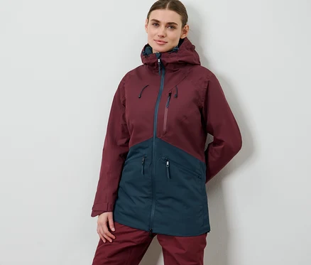 Femme posant en veste de ski et de snowboard.
