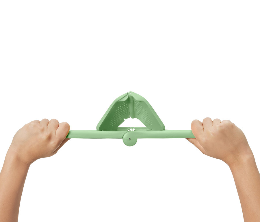 Deux mains tiennent un presse-agrumes compact vert.