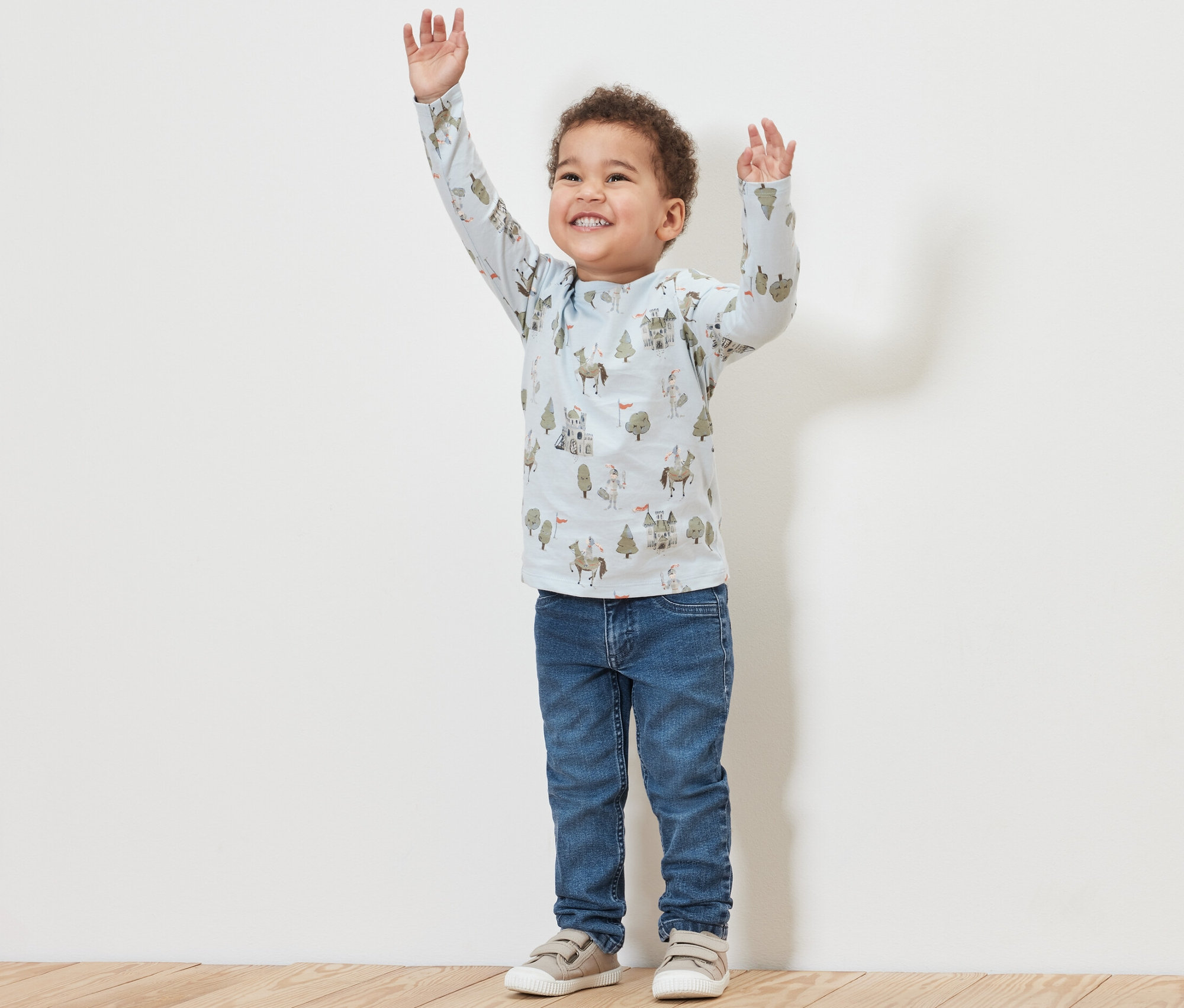 Un garçon aux bras levés porte un jean pour enfant – Fit « Jonas » et un t-shirt imprimé.