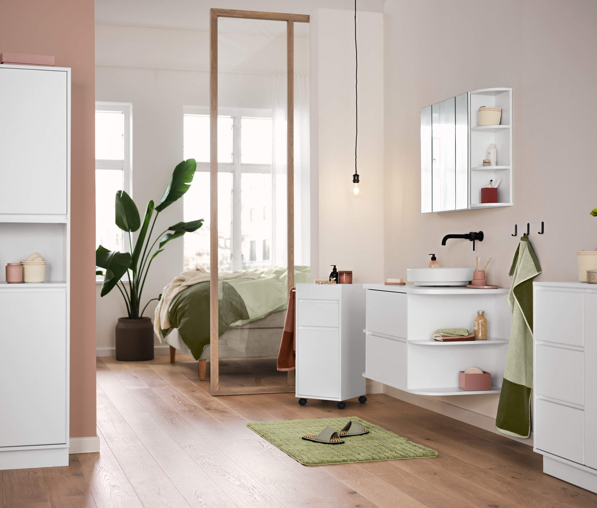 Dans une salle de bain, il y a des meubles de salle de bain blancs, un tapis de bain confort vert et des linges de toilette en jacquard de haute qualité vert sable-vert mousse sont suspendus.