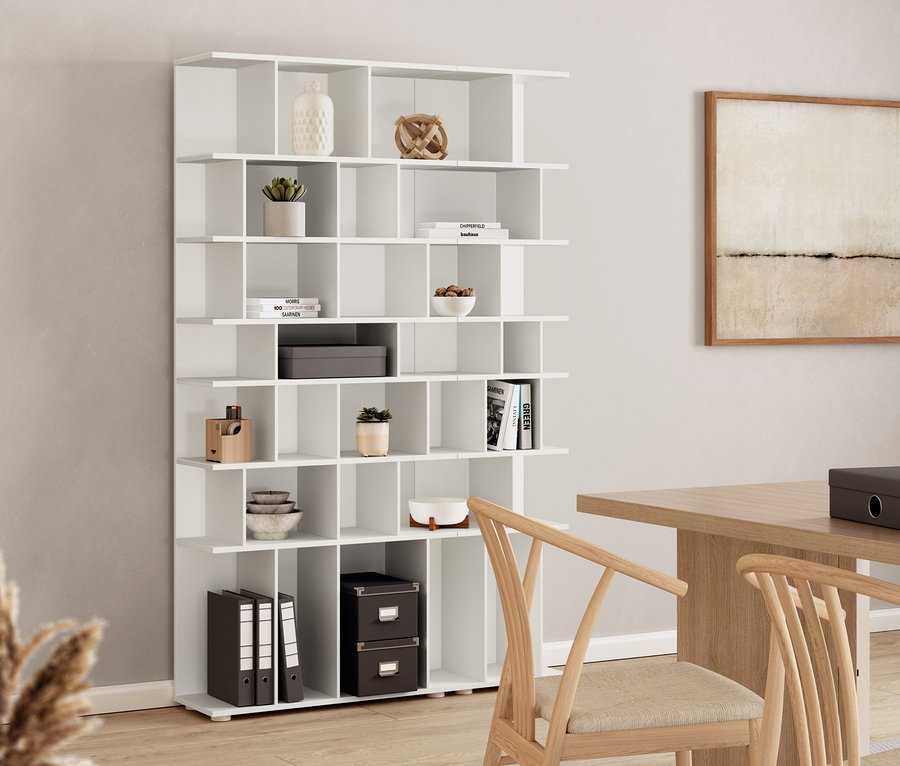 Une étagère blanche d'environ 80 cm de large se trouve à côté d'une table à manger et de chaises.