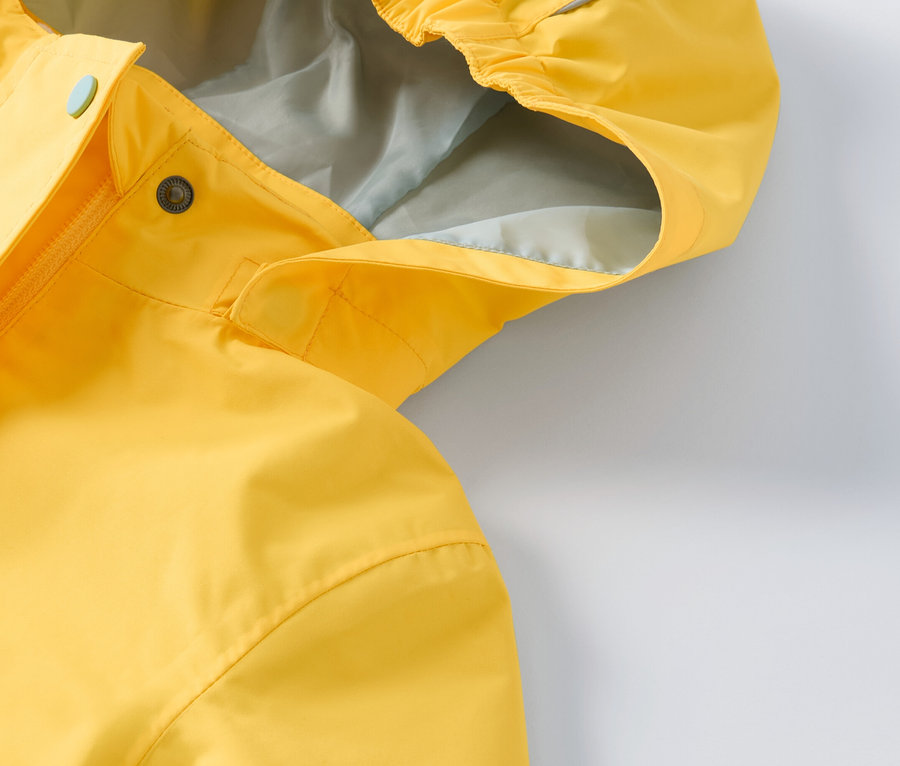 Gros plan sur une veste d’extérieur 3 en 1 jaune pour enfant.
