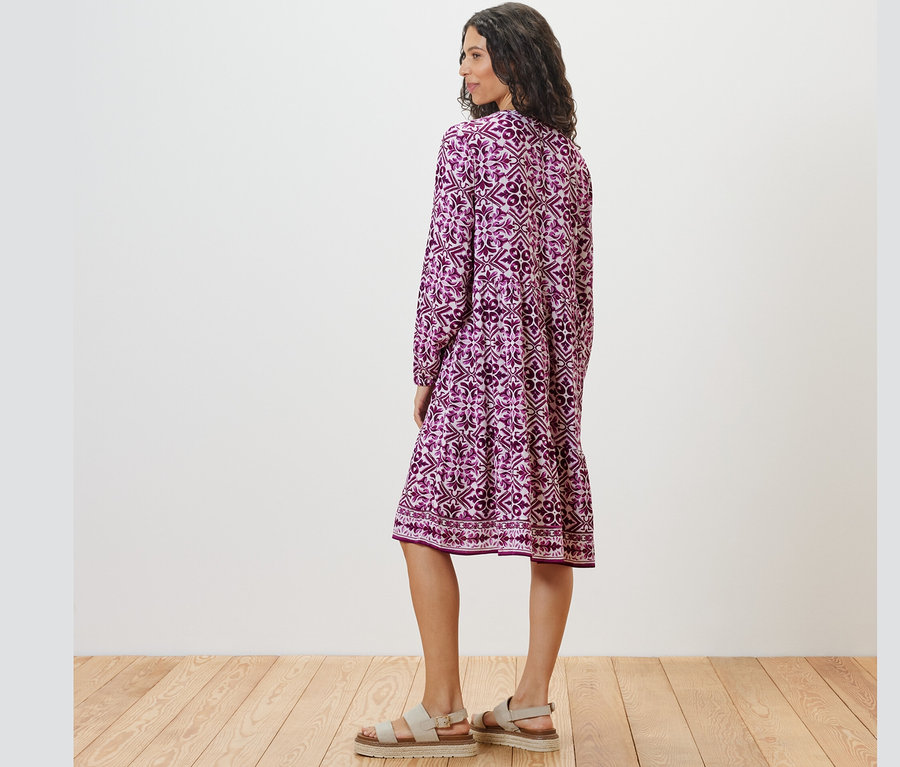 Femme posant de dos et portant une robe tissée imprimée.