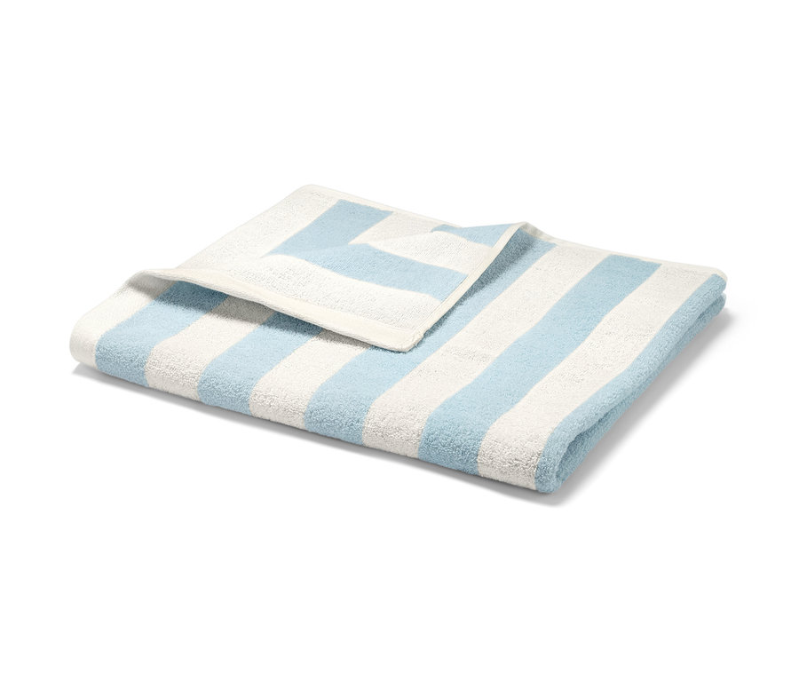 Serviette de bain pliée bleu clair et blanche à rayures.
