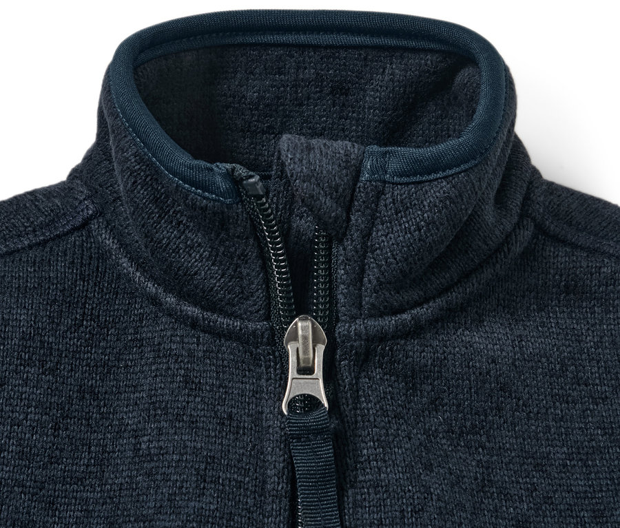 Gros plan sur une veste en maille polaire pour enfant avec une fermeture éclair ouverte.