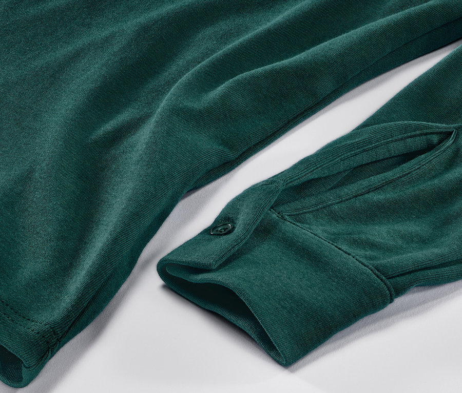Gros plan sur une blouse verte avec patte de boutonnage.
