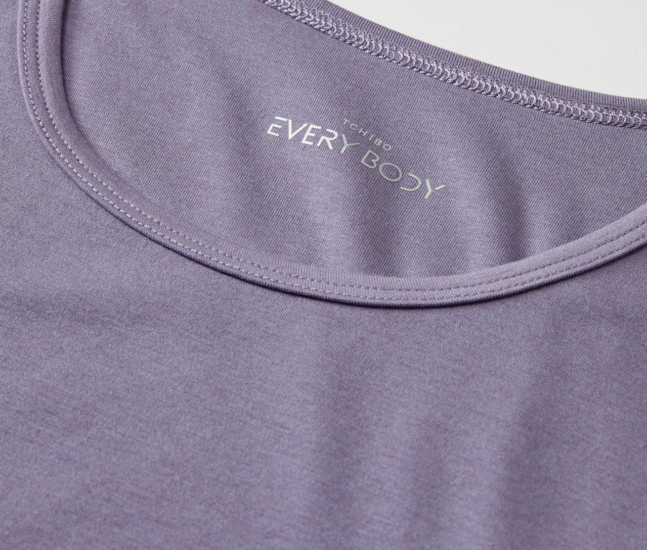Gros plan sur un t-shirt violet à col rond avec l'inscription "EVERY BODY".