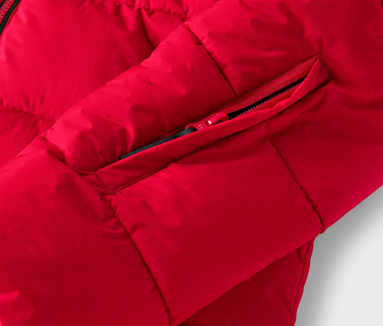 Détail d'une doudoune rouge avec une poche zippée.