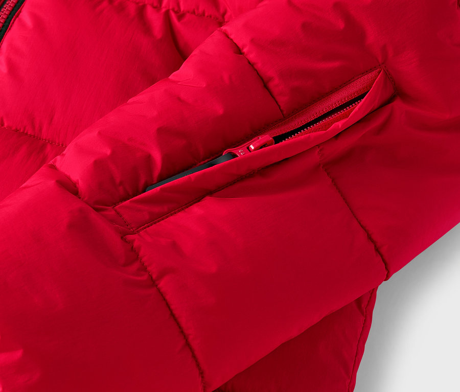 Détail d'une doudoune rouge avec une poche zippée.