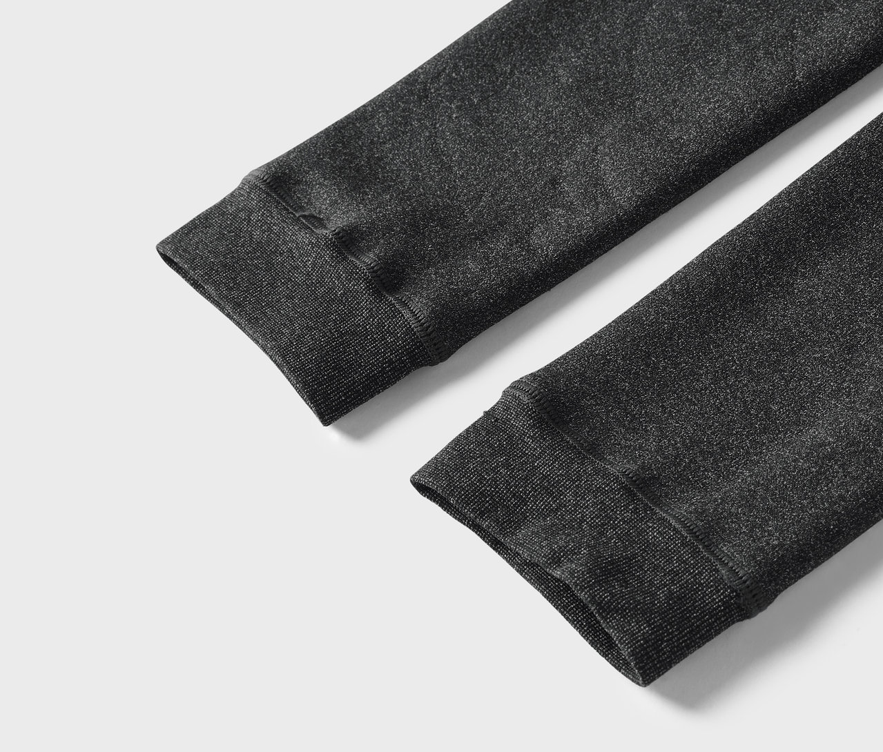 Gros plan sur les manches grises d'un sweat-shirt avec des poignets côtelés.