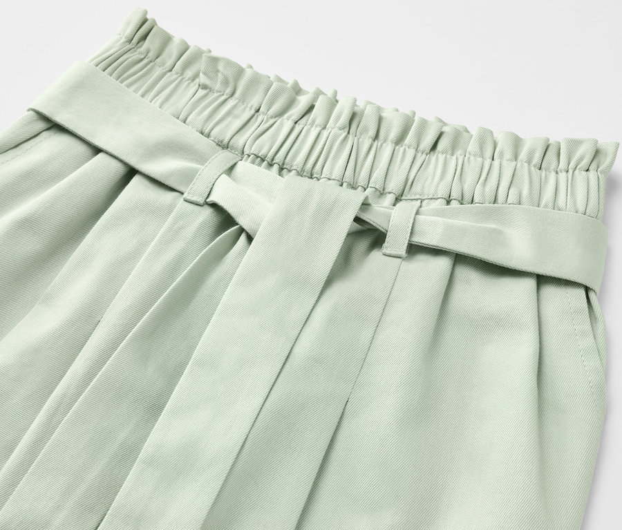 Détail d'un pantalon à enfiler pour enfant vert clair avec ceinture.