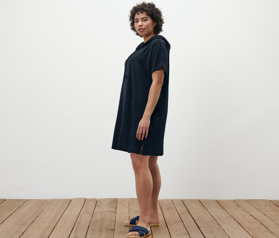 Femme posant en robe de plage en tissu éponge bleue.