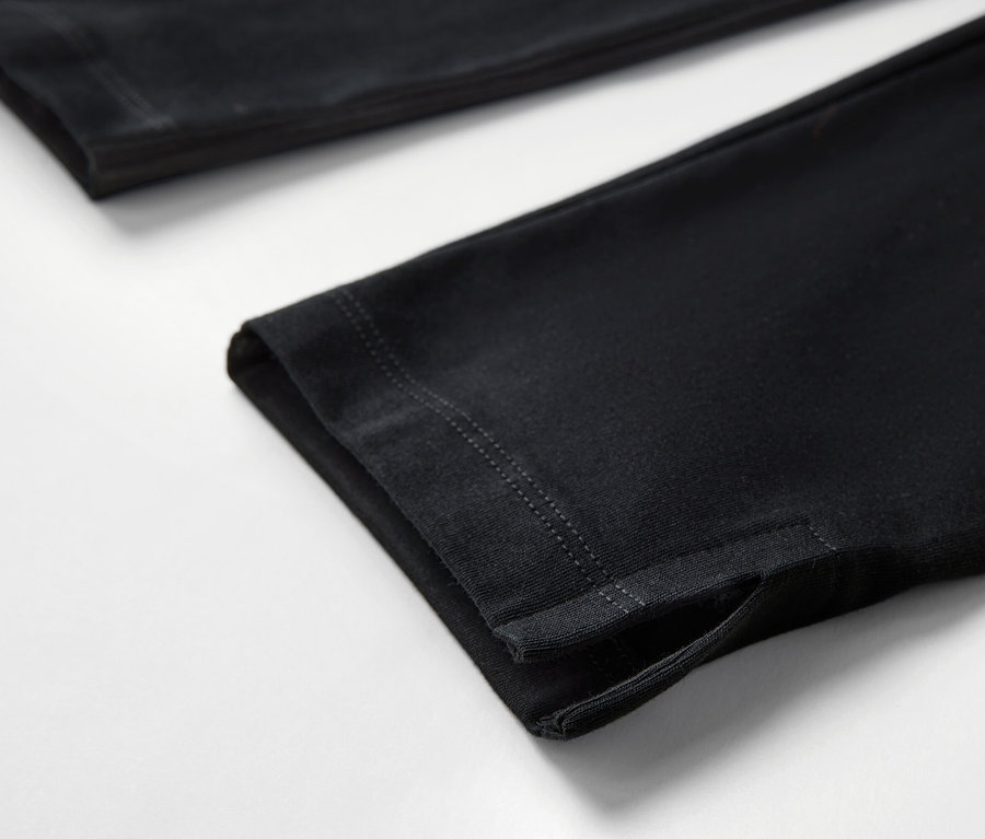 Gros plan sur un legging 3/4 noir avec ourlet sur fond blanc.